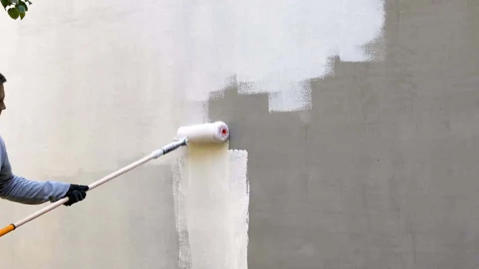 Maler ruller en pudset facade